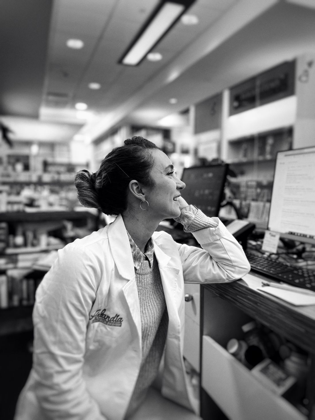 Dr. Marin Calloway, Head of Research &amp; Quality, in the lab. A real working portrait — shirtsleeves, holding a vial or a signed COA, natural light, looking straight at you. Not a stock headshot.