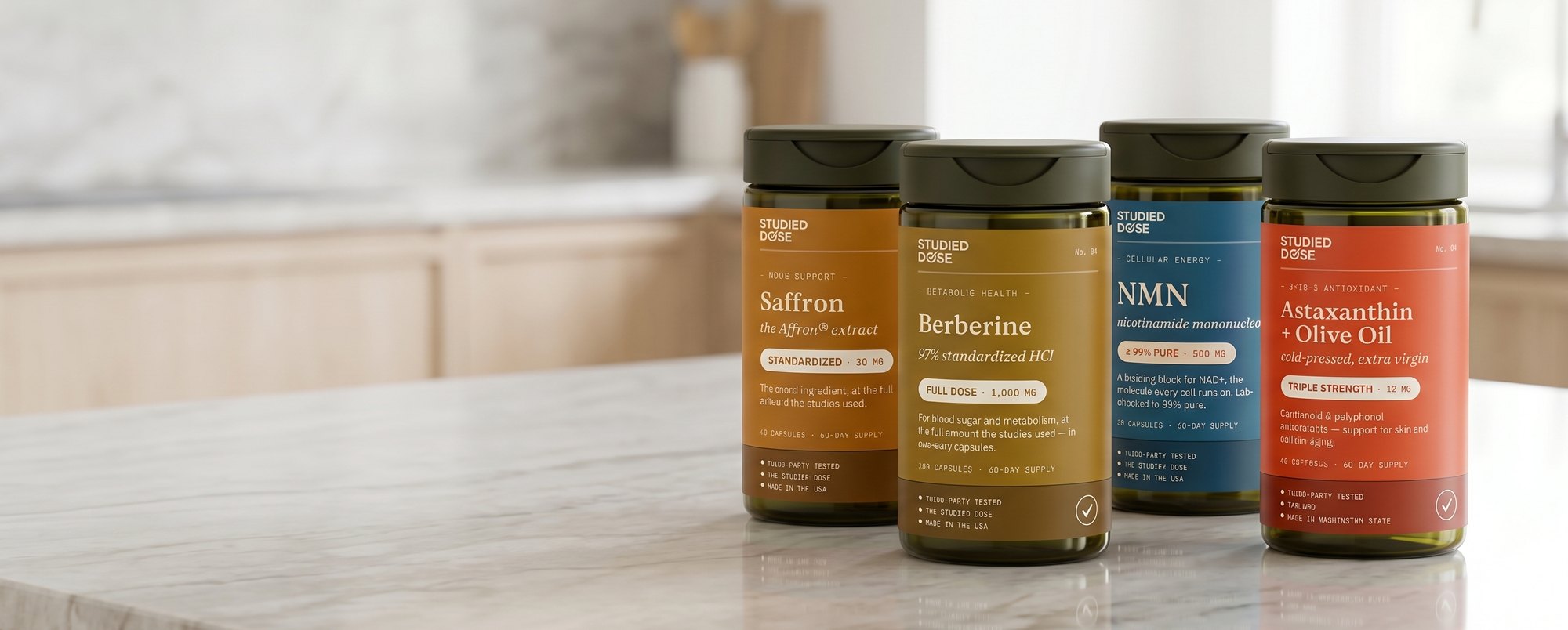 The Studied Dose lineup — Astaxanthin, Saffron, Berberine, NMN — on a kitchen counter