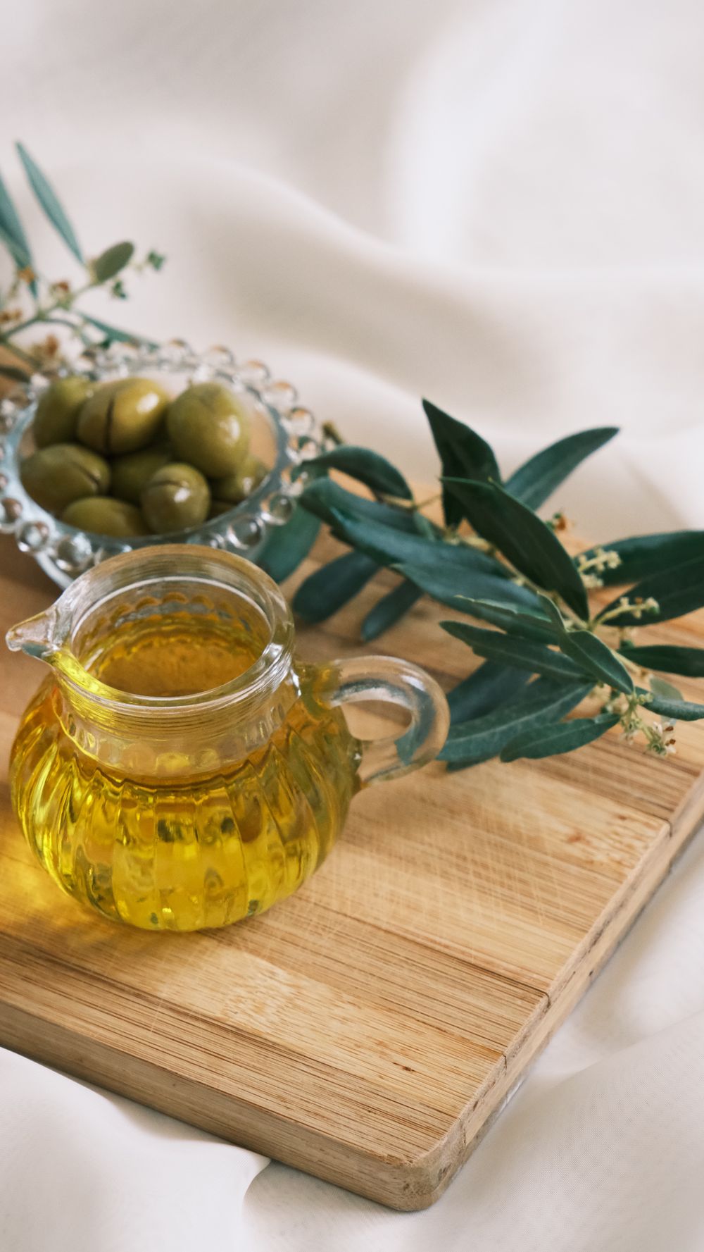 The first cold press of the season in Puglia: green olive oil running, stone and steel, an old grove out the window. Golden hour, documentary.